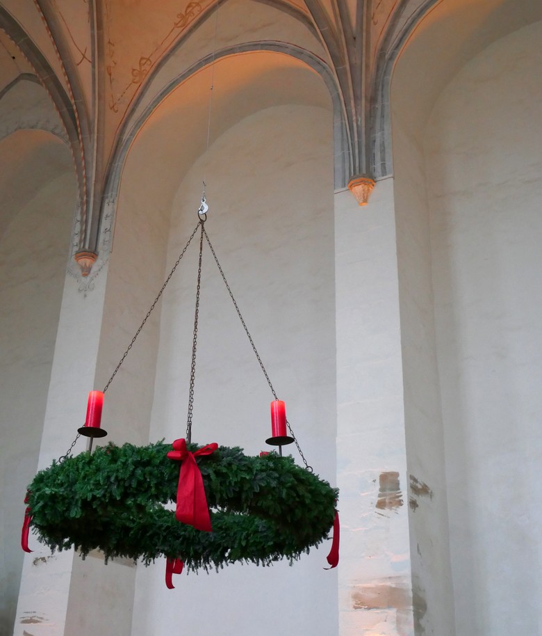 Ein Adventskranz in einer Kirche.